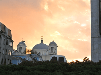 Foto de uma igreja com o céu alaranjado